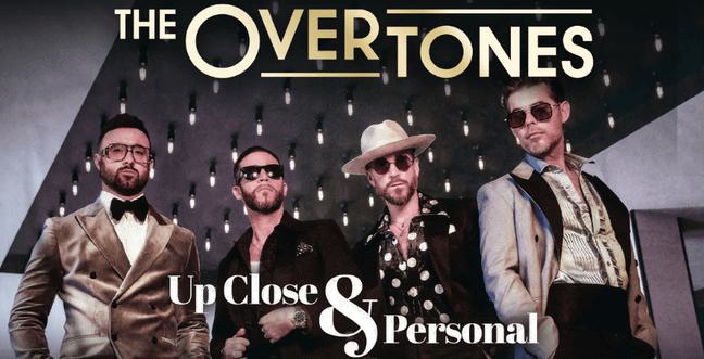 Four men in gold and black suits stand in front of a black lit-up backdrop with the title 'The Overtones Up Close and Personal'