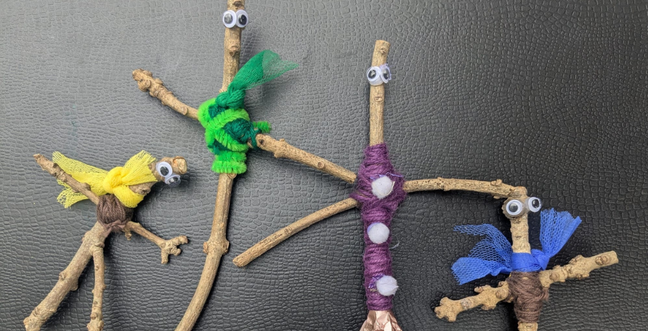 A collection of sticks dressed up in fabric with googly eyes