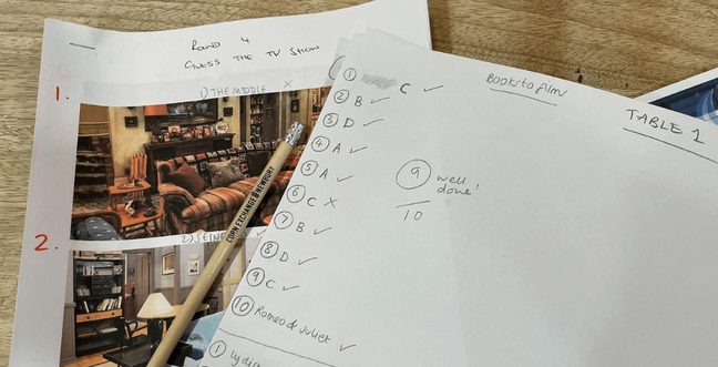 A selection of answer sheets are spread on a table with a Corn Exchange pencil and a score marked 9/10