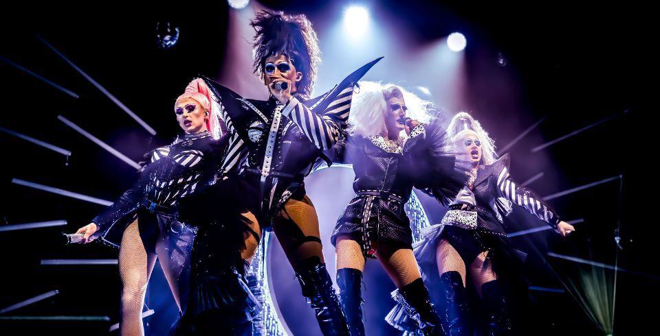 A group of performers on stage in black and white outfits