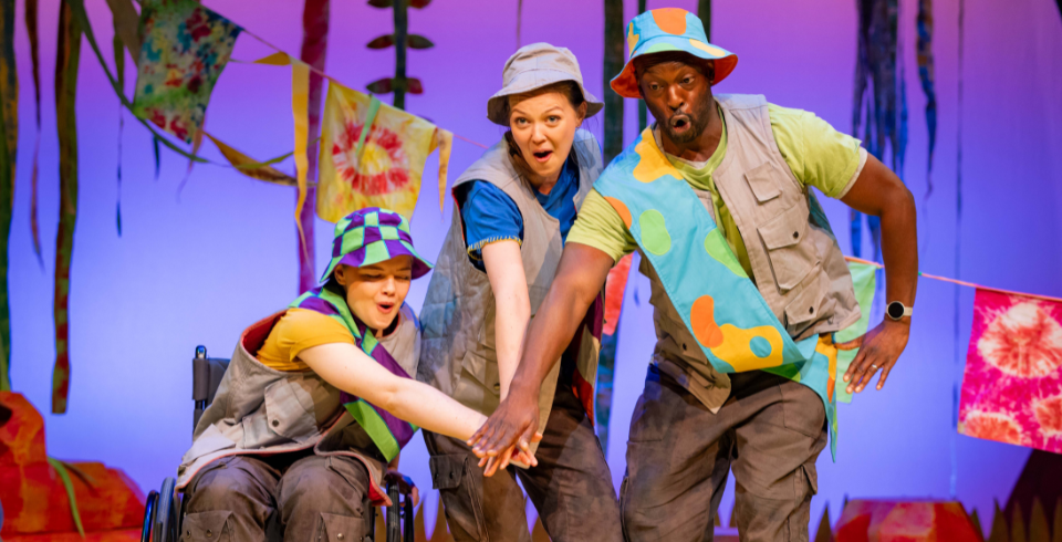 A group of people on stage wear colourful bucket hats and grey camo wear