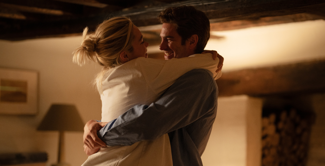 Man and woman hugging in a warmly lit room.