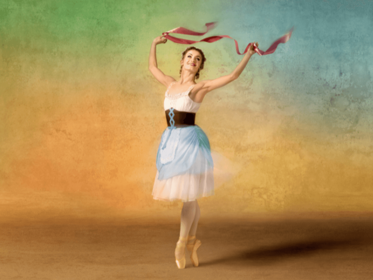 A ballerina in a maid outfit dances on pointe while holding ribbons up in the air