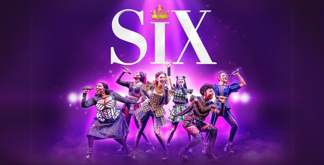 six women in tudor style costumes singing into microphones on a dark purple background with a pink spotlight highlighting them. the letters SIX above them