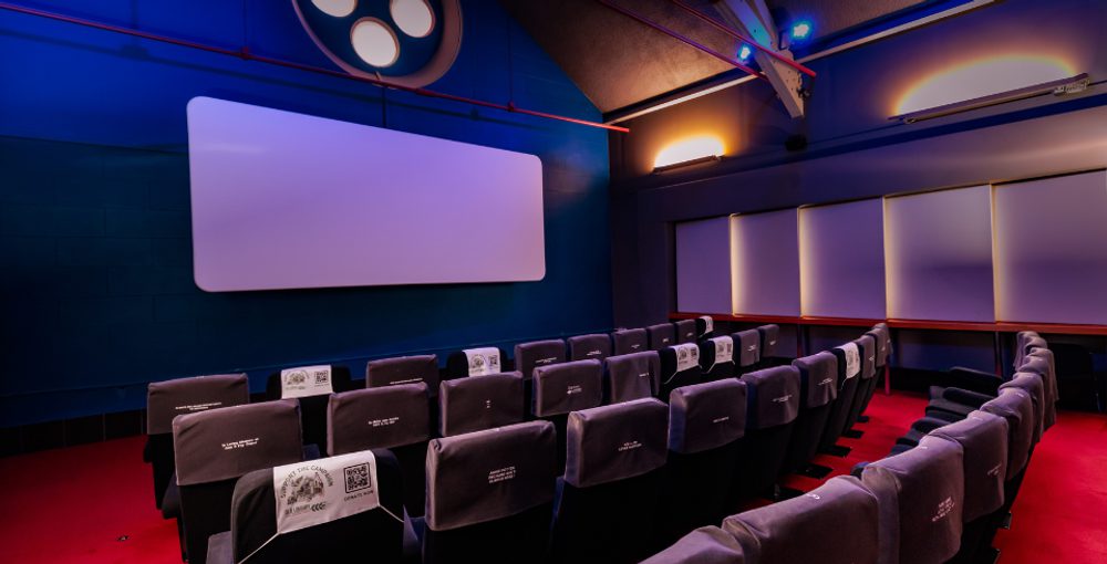 A 40-seat cinema, with purple covered seats, red carpet and blue lighting