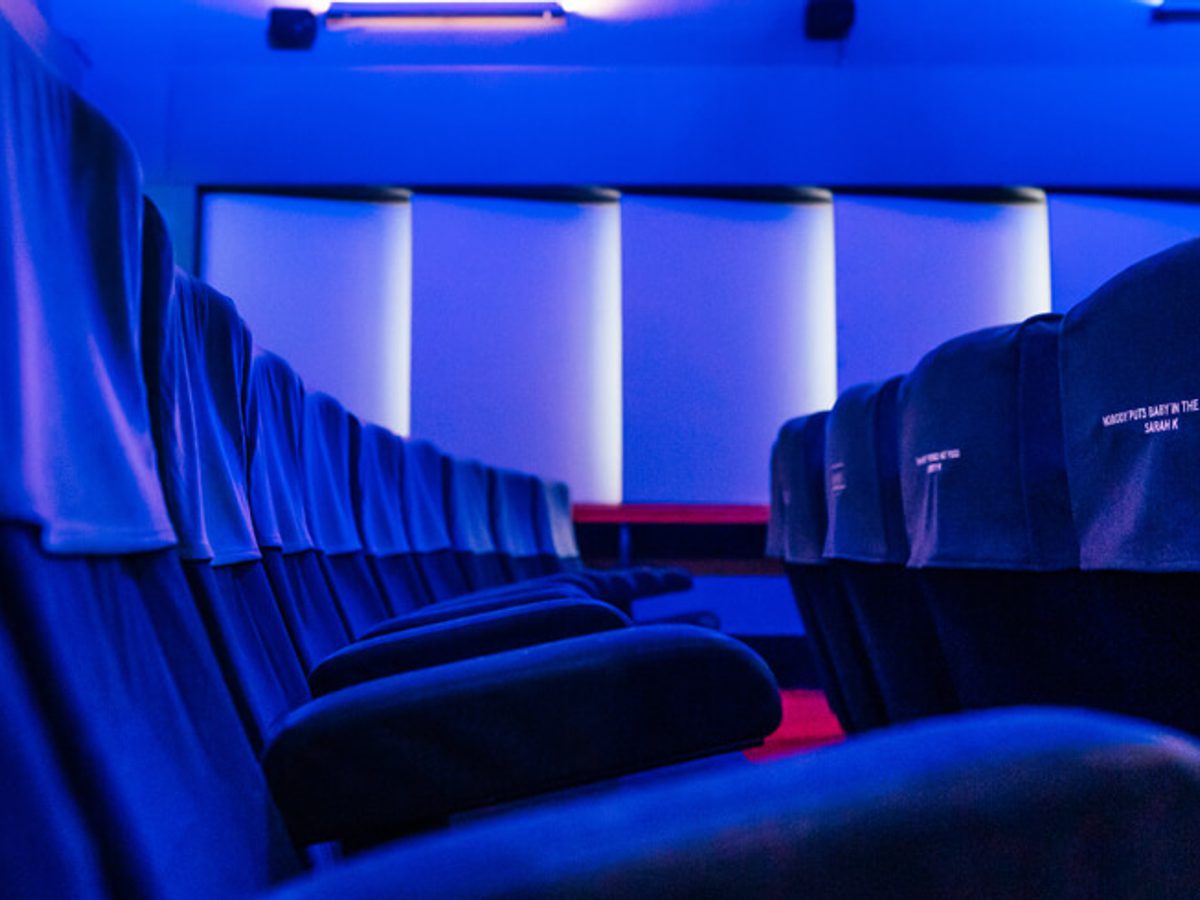 Lit in blue light is a row of cinema seats