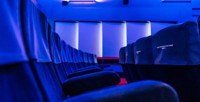 Lit in blue light is a row of cinema seats