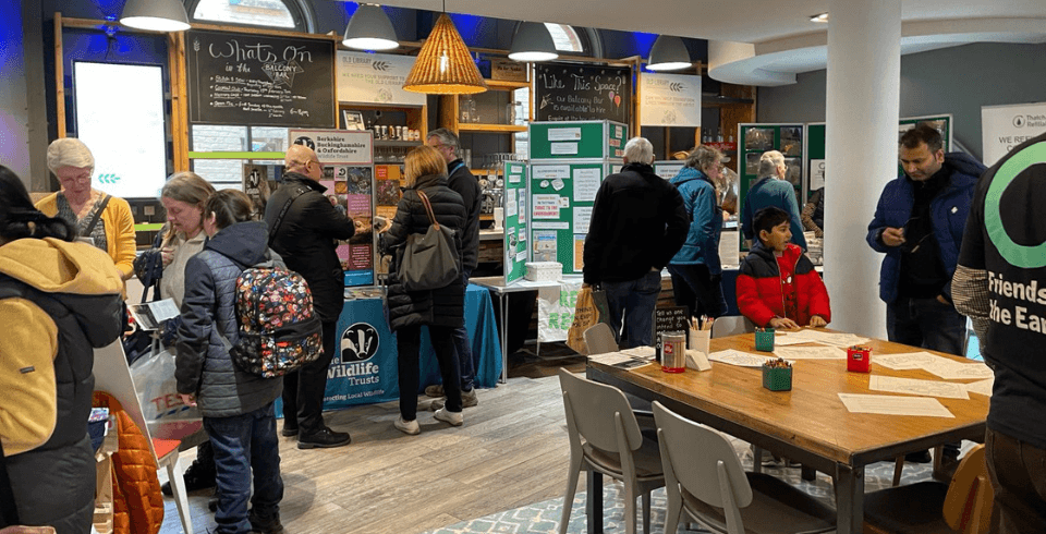 A group of people walking around browsing stalls in the Balcony Bar