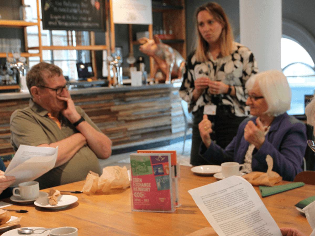 A group of elderly people sit together in a deep discussion with one of our practitioners