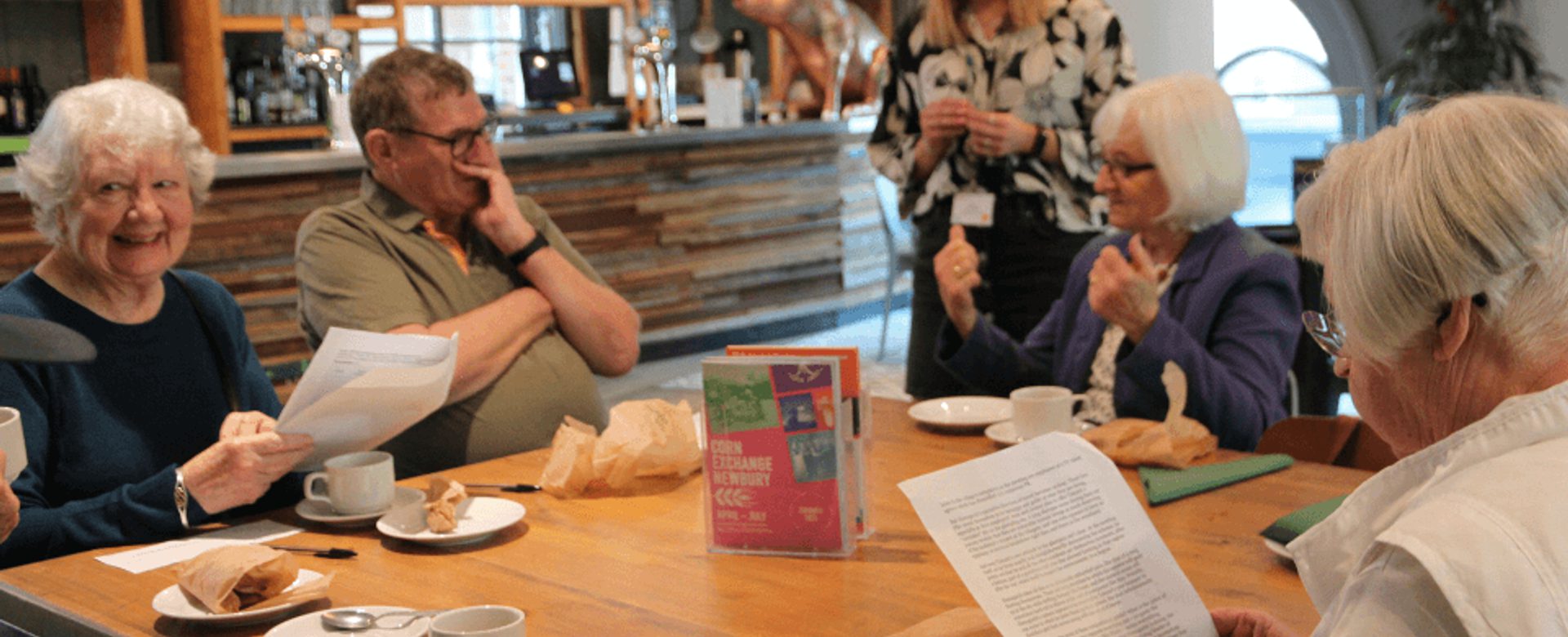 A group of elderly people sit together in a deep discussion with one of our practitioners