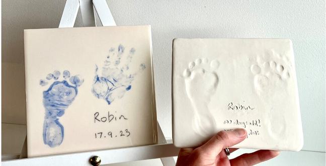 two clay prints with footprints of babies feet one in blue and one an outline