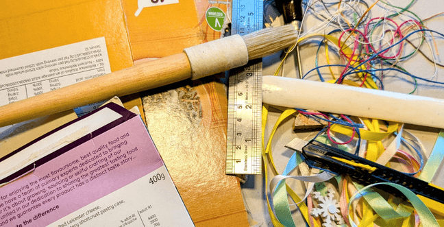 A collection of cardboard, ribbon, a ruler and a brush