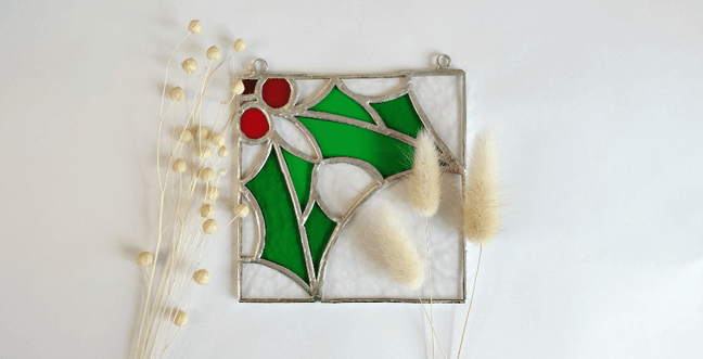 A stunning square stained glass panel of a sprig of holly
