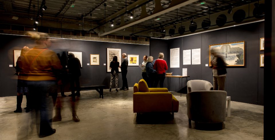 A gallery setting with blurry people walking around