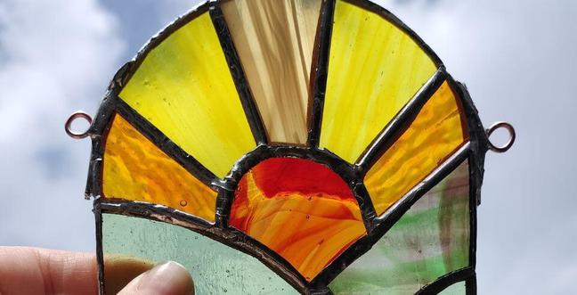 A sunrise pattern made out of yellow and orange stained glass