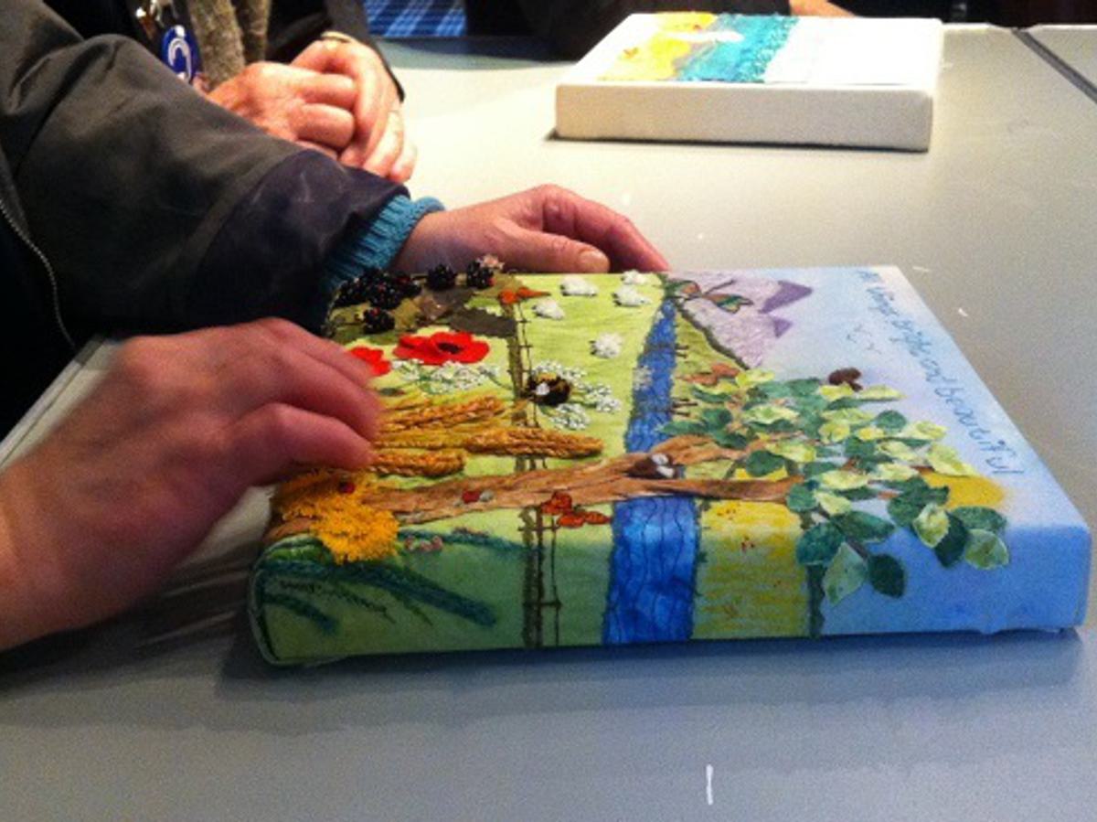 An image of someone feeling a painting with their hands.