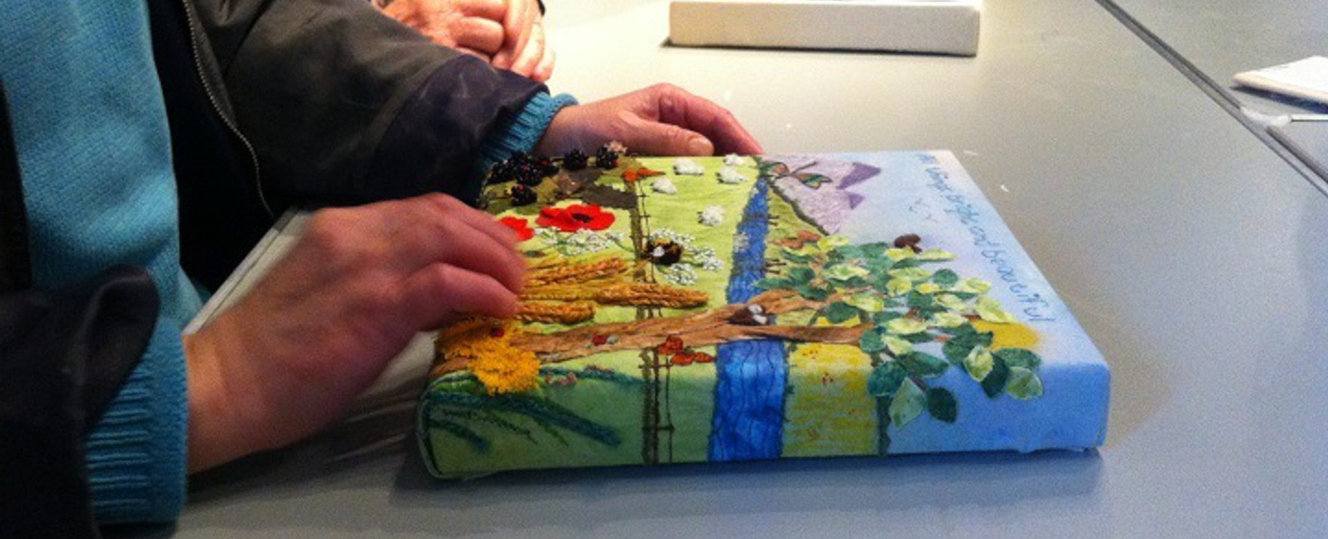 An image of someone feeling a painting with their hands.
