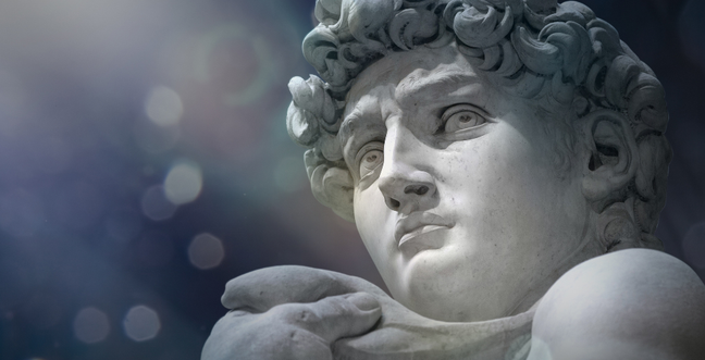 A close-up of Michelangelo's David, showcasing his intense gaze and detailed curls, with a soft, speckled background.