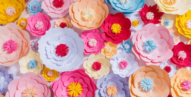 A collage of brightly coloured flowers made from paper.